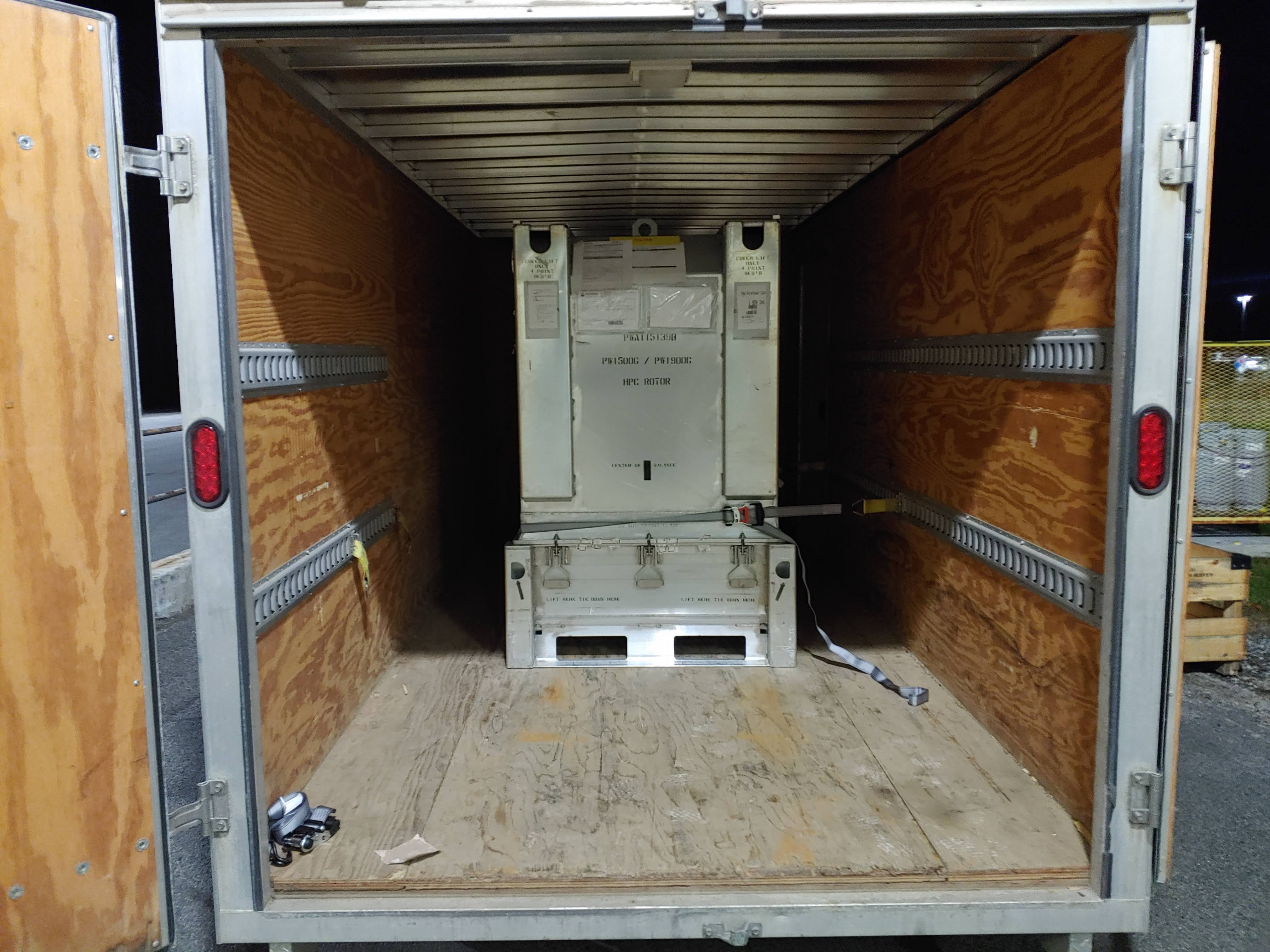 Industrial crate strapped down inside a Comet Couriers cargo trailer
