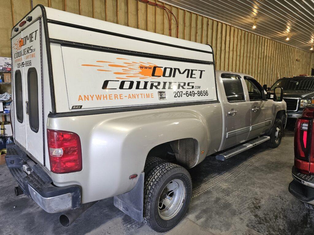 Comet Courier pickup truck with a small truck cap parked inside the Comet Couriers warehouse.